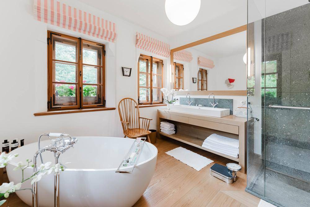 Modernes Badezimmer mit freistehender Badewanne, Doppelwaschbecken und begehbarer Dusche, hell und geräumig.