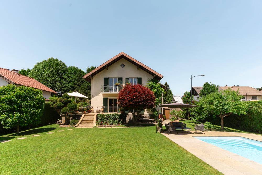 Weitläufiger Garten mit Swimmingpool, Liegefläche und Sitzbereich vor dem charmanten Wohnhaus.