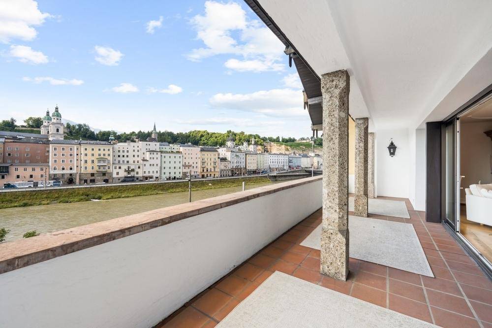 Breite Terrasse mit Fliesenboden und weitem Blick über die Stadt und den Fluss.