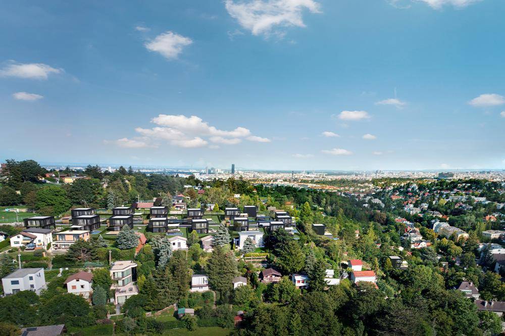 Luftaufnahme einer modernen Wohnsiedlung in grüner Hügellandschaft mit Fernblick auf die Stadt.
