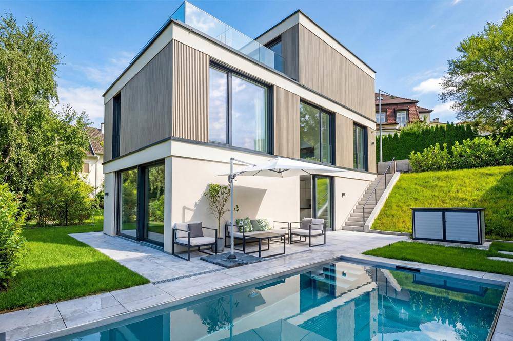 Modernes Einfamilienhaus mit großzügiger Terrasse, Swimmingpool und gepflegtem Gartenbereich.