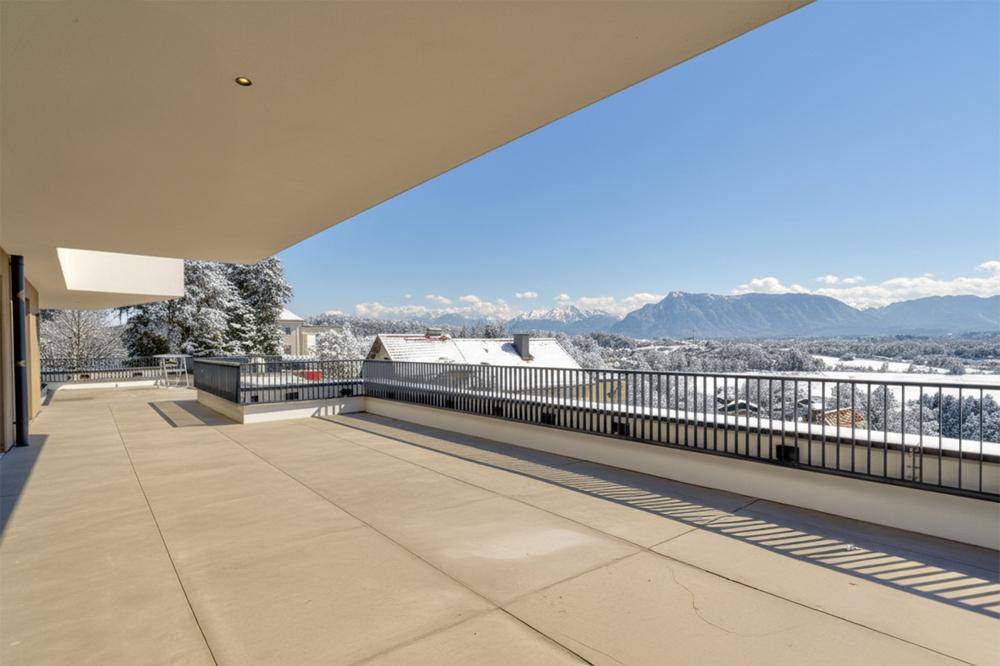 Großzügige Dachterrasse mit atemberaubendem Panoramablick auf die verschneite Berglandschaft und die Umgebung.