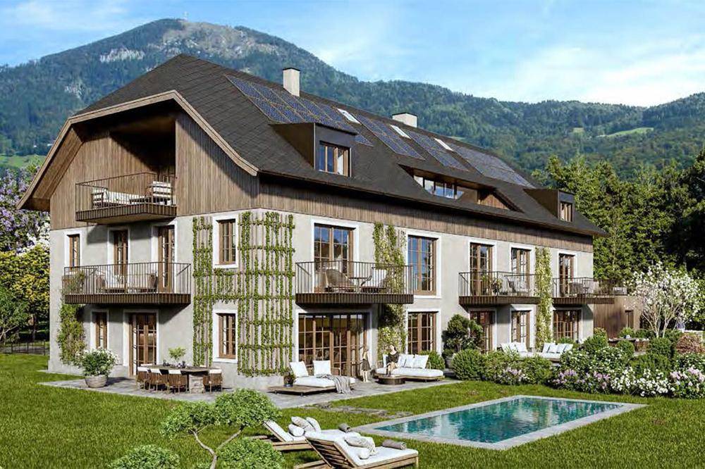 Attraktives Landhaus mit Pool, Balkonen und Photovoltaikanlage vor malerischer Bergkulisse.