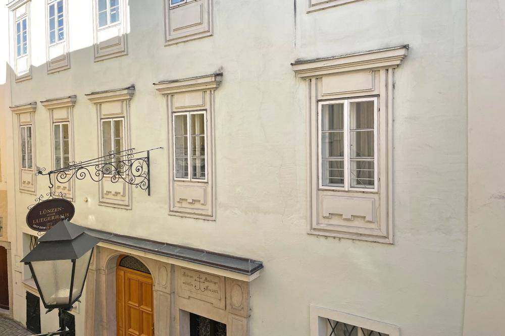 Historische Fassade mit traditionellen Fenstern und einem schmiedeeisernen Ausleger.