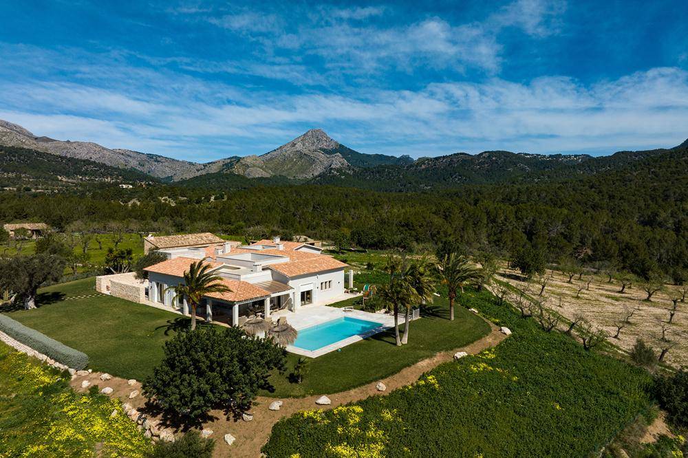 Weitläufige Ansicht der Villa mit Pool, umgeben von grünen Hügeln und Weinbergen.