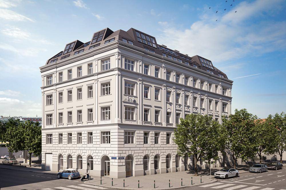 Elegantes Altbaugebäude mit klassischer Fassade und modernem Dachausbau in urbaner Umgebung.