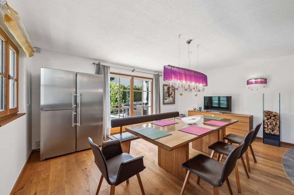 Heller Wohn- und Essbereich mit Holzboden, großem Kühlschrank und Zugang zur Terrasse.