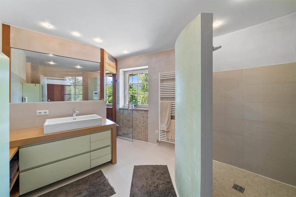 Das Bad en suite mit ebenerdiger Regendusche ...
