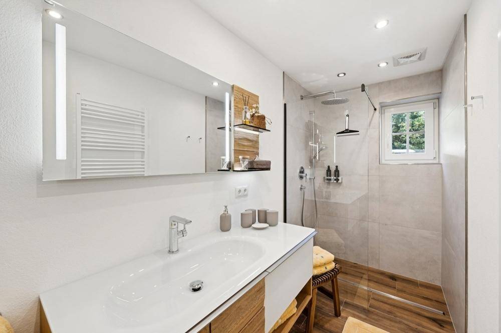 Das freundliche Tageslicht-Badezimmer mit Regendusche