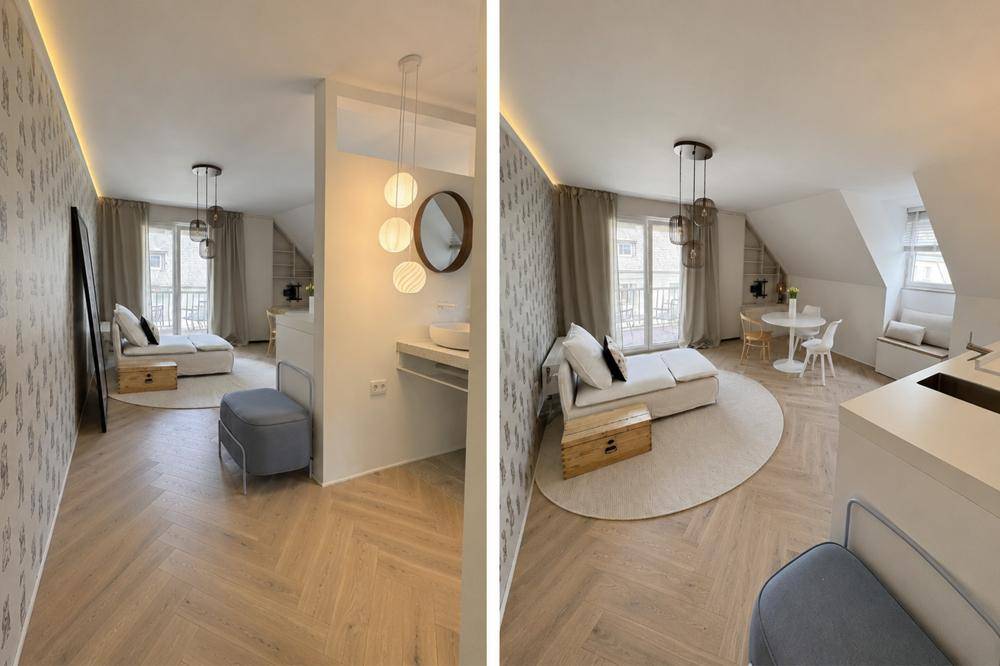Offener Wohnbereich mit moderner Einrichtung, Holzboden und Zugang zu einem französischen Balkon.
