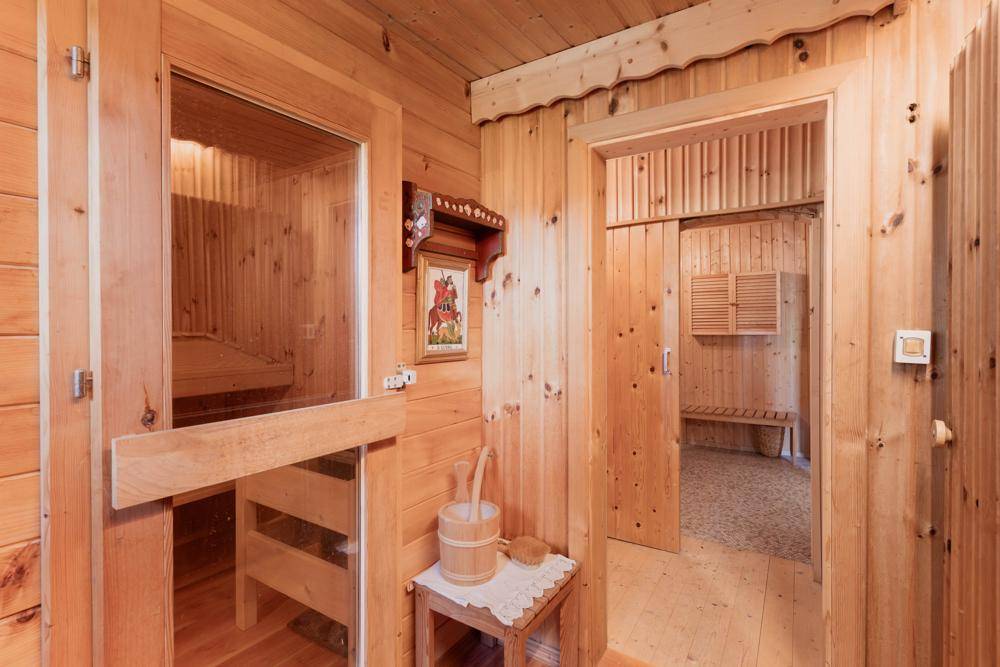 Gemütlicher Wellnessbereich mit Holzvertäfelung, Sauna und einem weiteren Raum zur Entspannung.