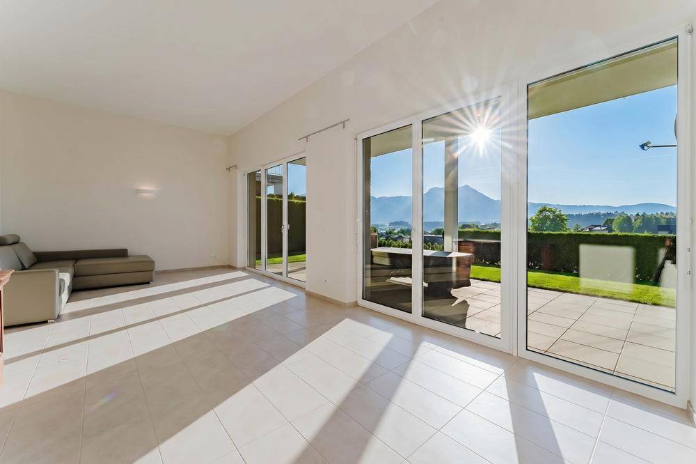 Helles Wohnzimmer mit Fliesenboden und direktem Zugang zur sonnigen Gartenterrasse.