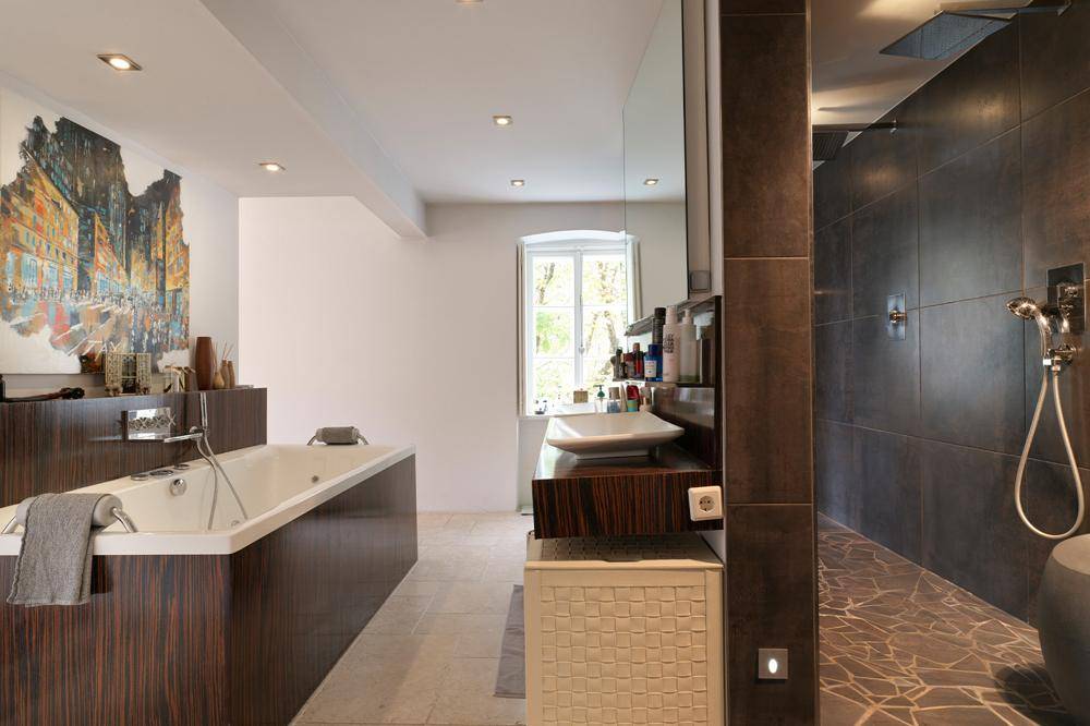 Modernes Badezimmer mit Badewanne, begehbarer Dusche und stilvollem Waschtisch.
