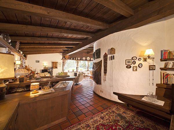 Traditioneller Wohnbereich mit Holzbalkendecke, Terrakottafliesen und rustikalen Möbeln.