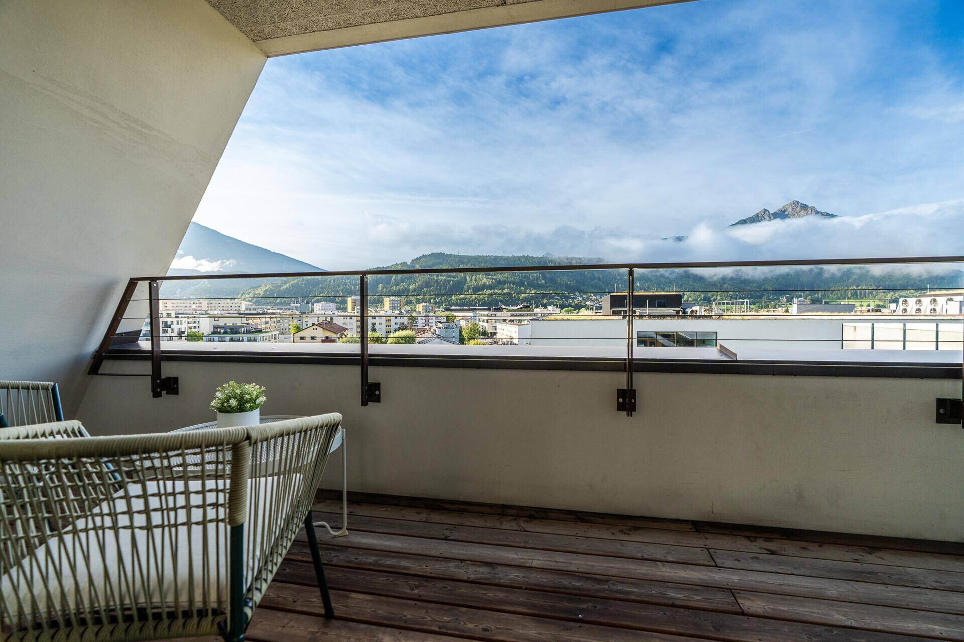 Balkon mit bequemen Outdoor-Möbeln und beeindruckendem Panoramablick auf die umliegende Bergwelt.