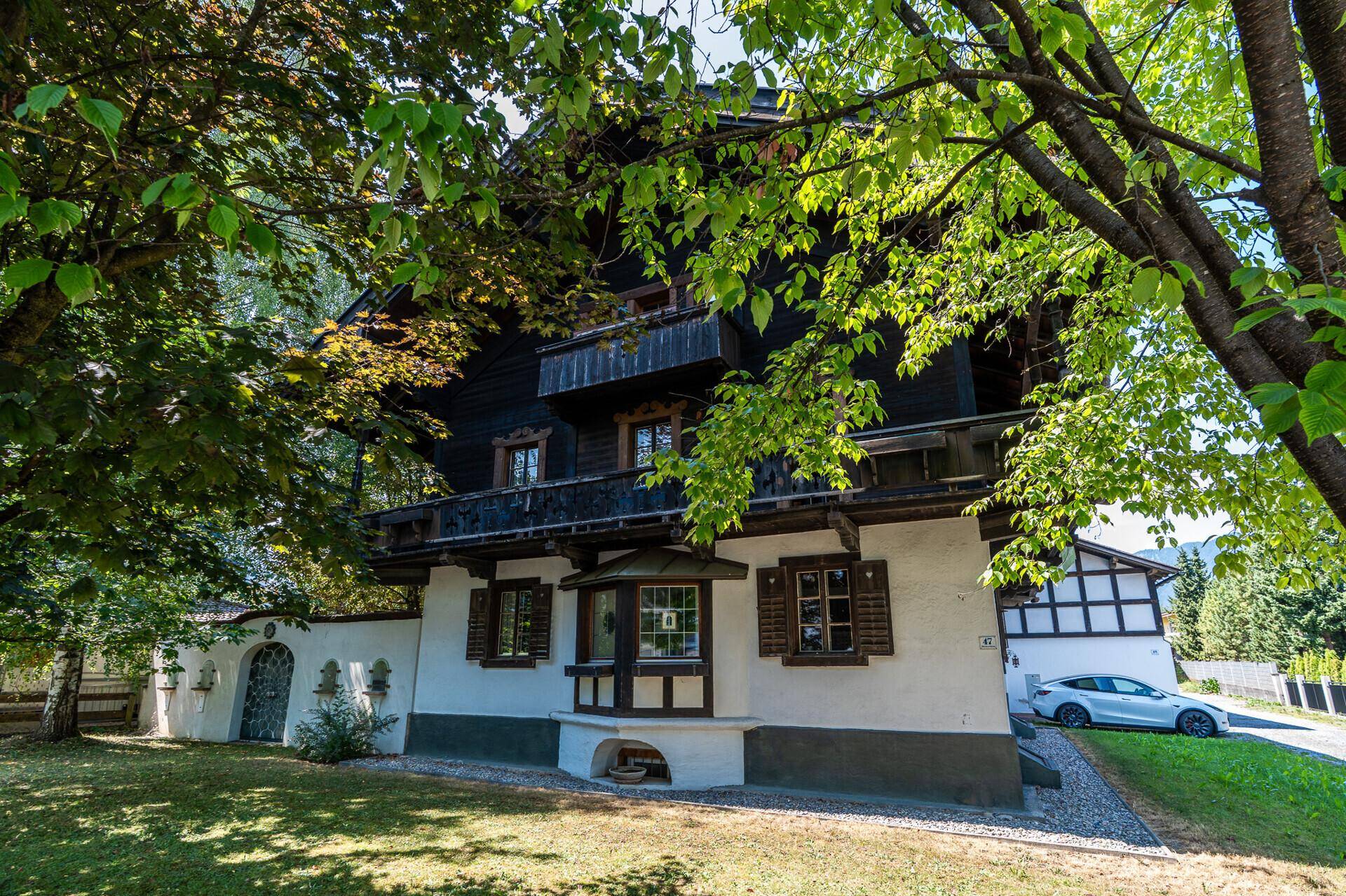 Traditionelle Hausfassade mit Holzelementen, Erker und gepflegtem Vorgarten.