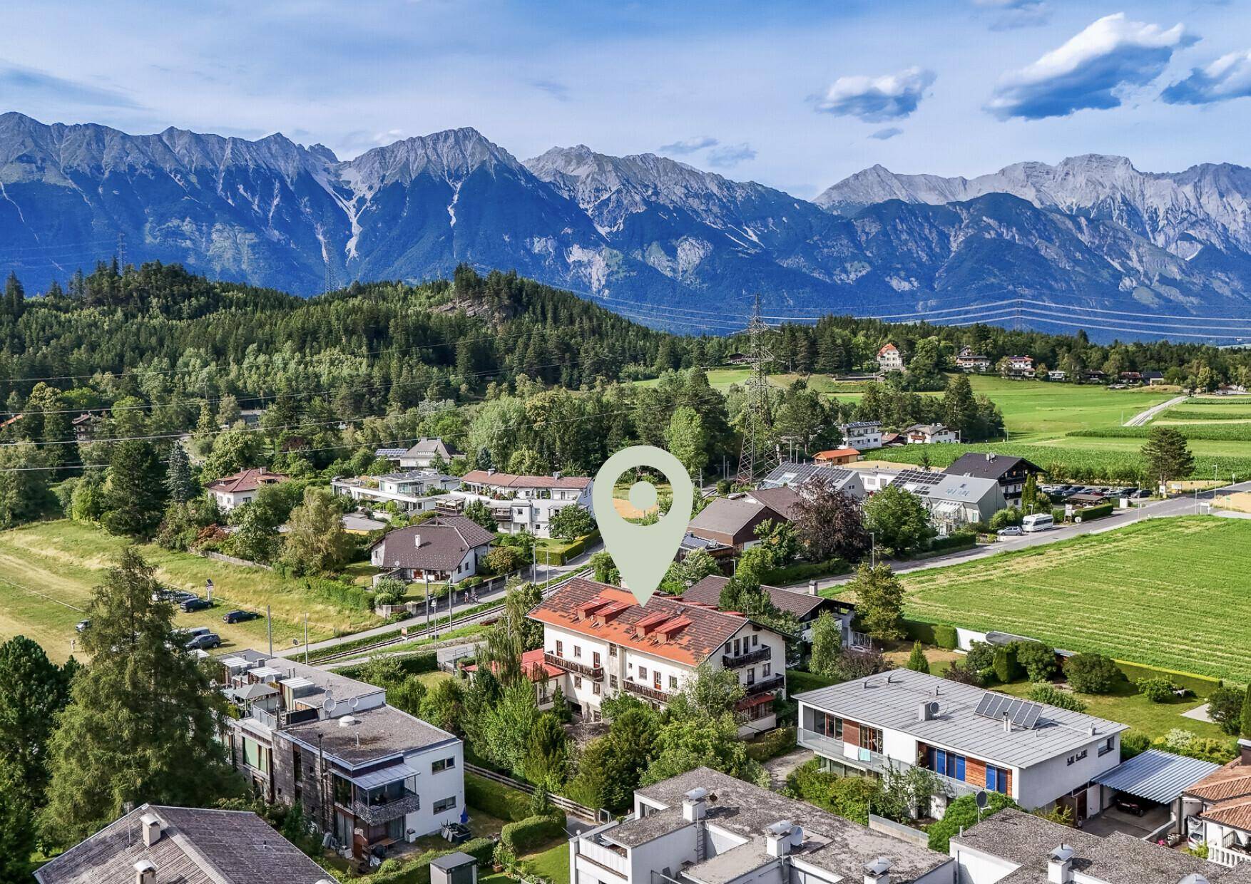 Weitläufige Luftaufnahme eines Gebäudes mit beeindruckendem Bergblick und ländlicher Umgebung.
