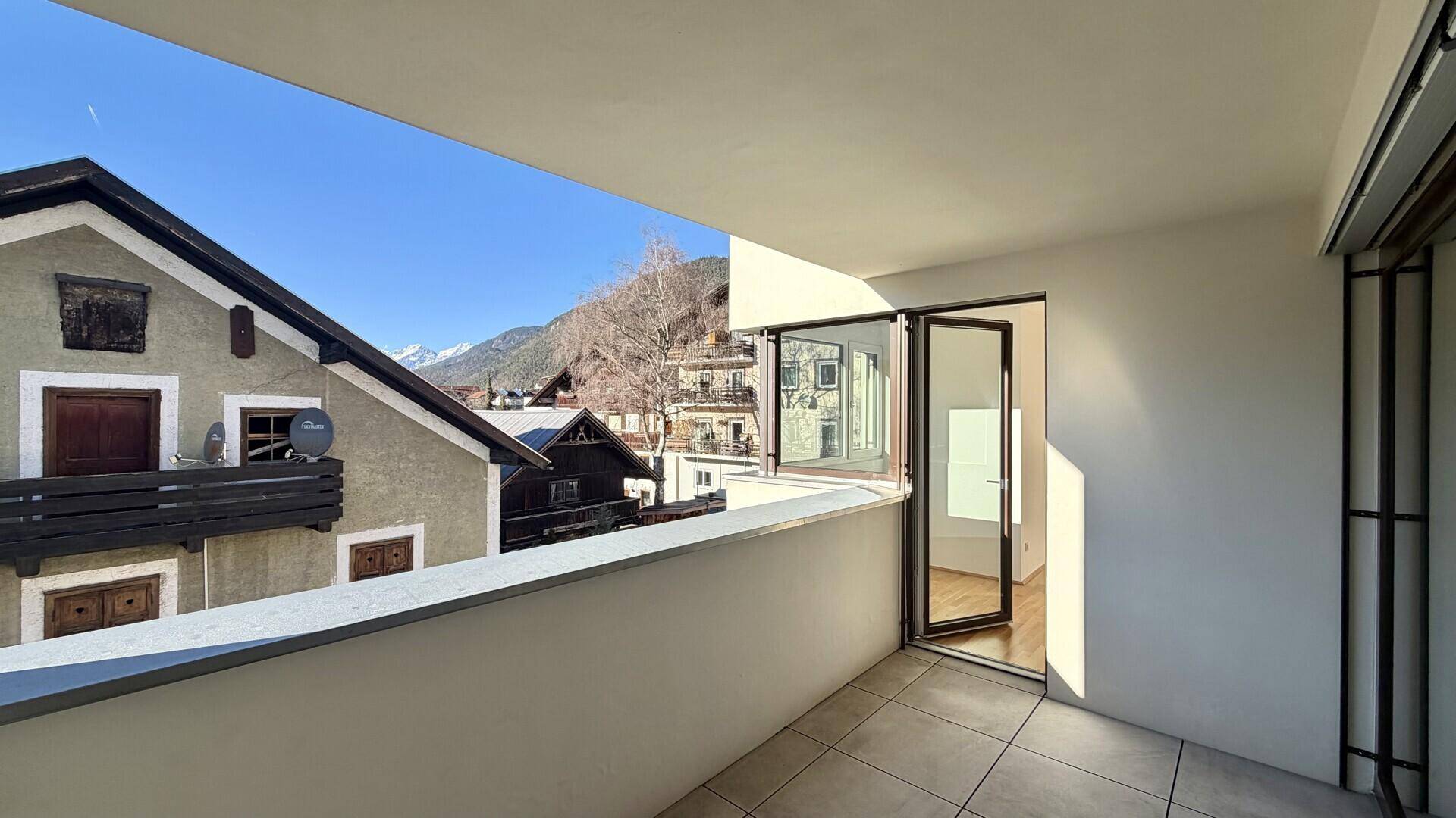 Geräumiger Balkon mit Fliesenboden und herrlichem Blick auf die umliegenden Berge.