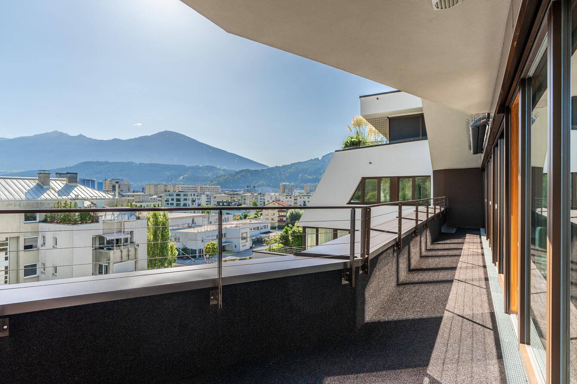 Langer Balkon mit Bergblick und Stadtpanorama, ideal für entspannte Stunden im Freien.