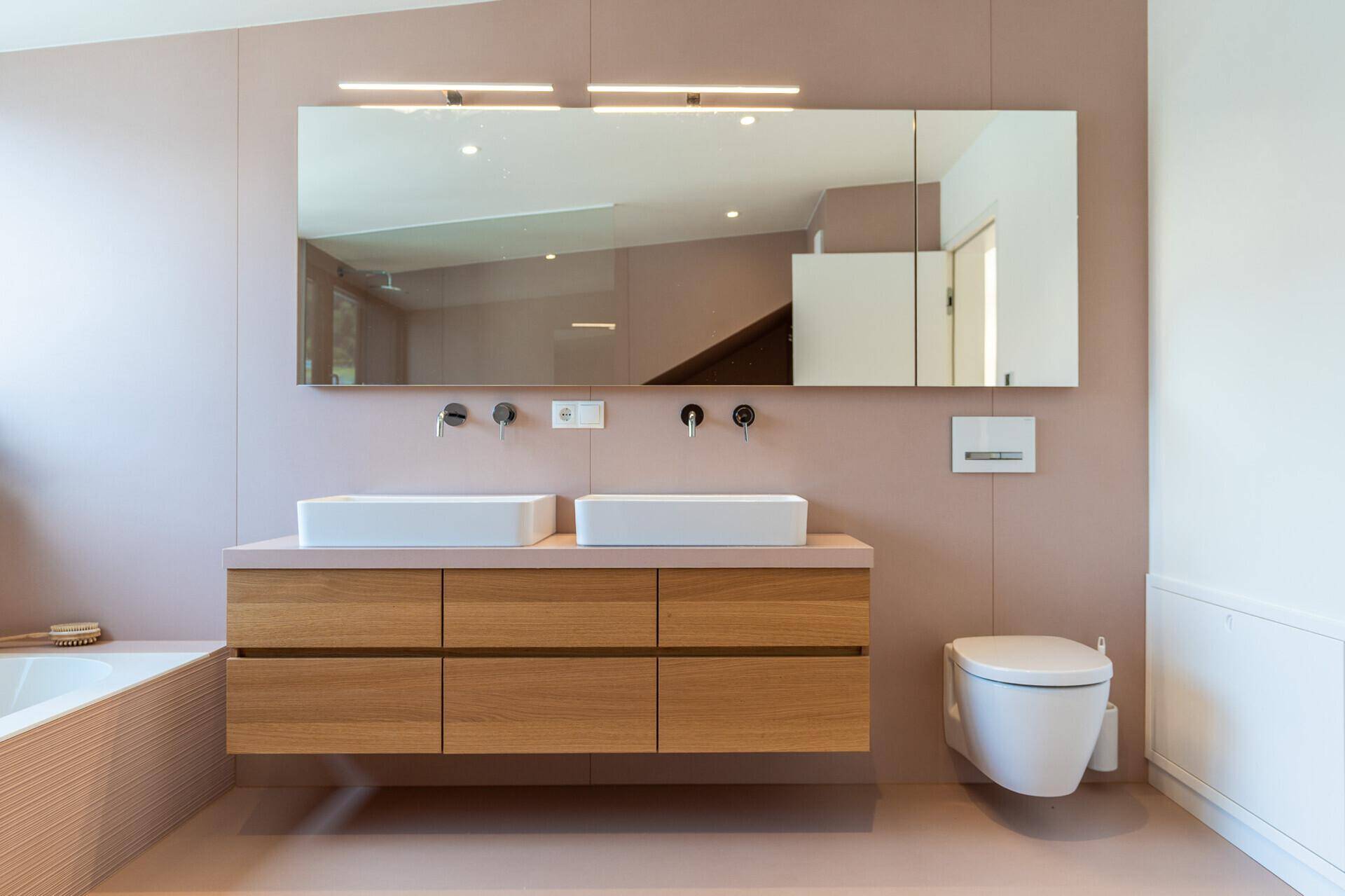 Elegantes Badezimmer mit Doppelwaschbecken, großem Spiegel und schwebendem Holzwaschtisch.