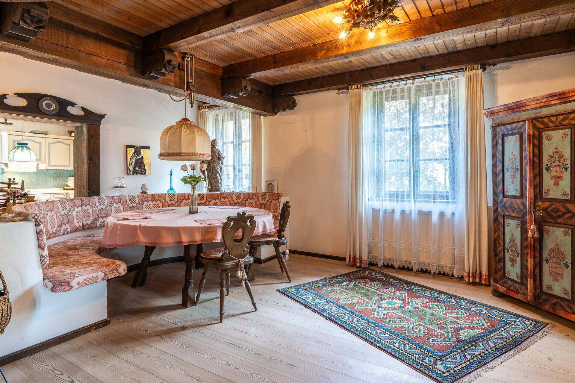 Gemütlicher Essbereich mit traditioneller Eckbank, Holzbalkendecke und rustikalen Möbeln.