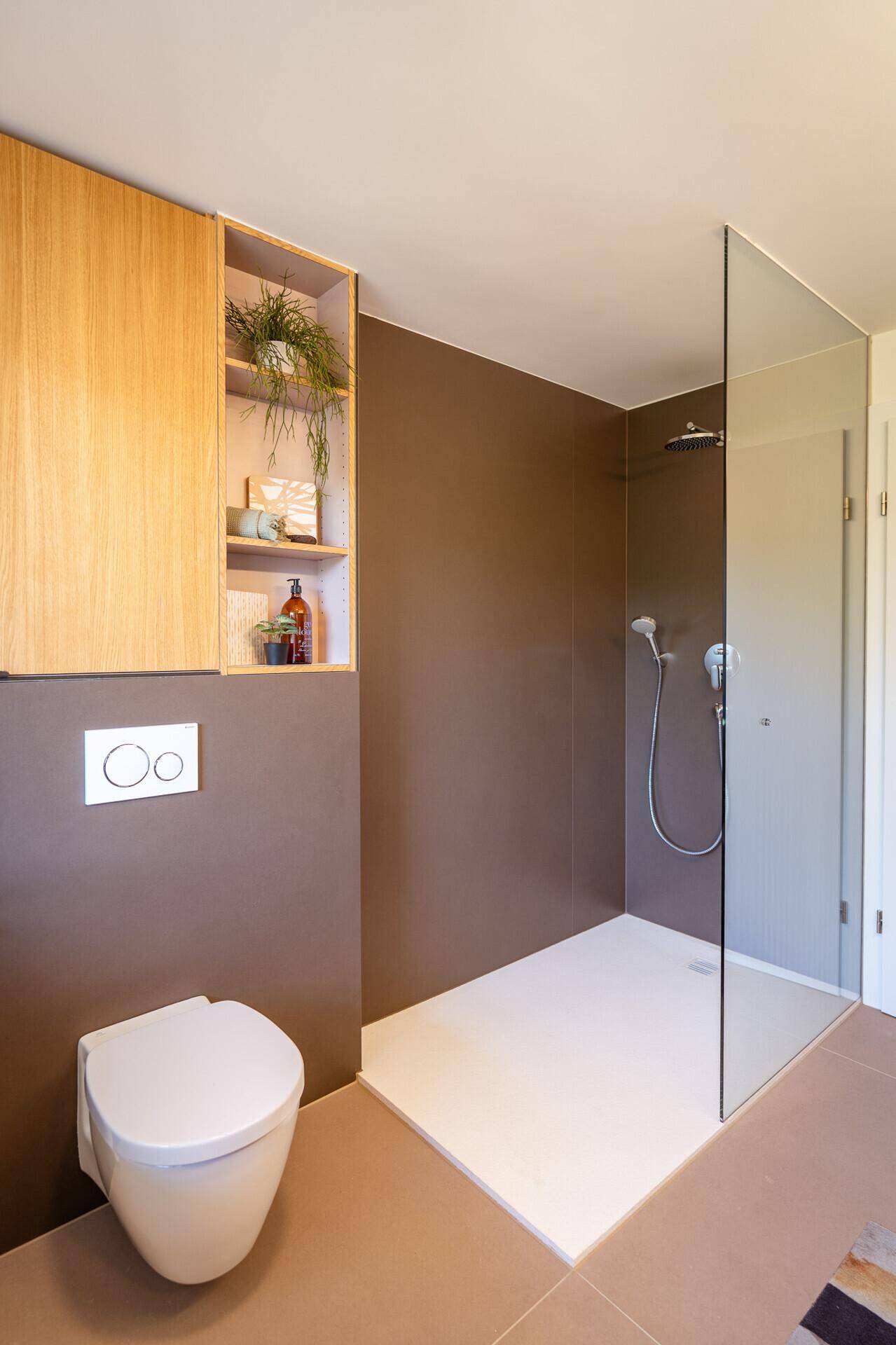 Modernes Badezimmer mit begehbarer Dusche, Wand-WC und Holzschrank.