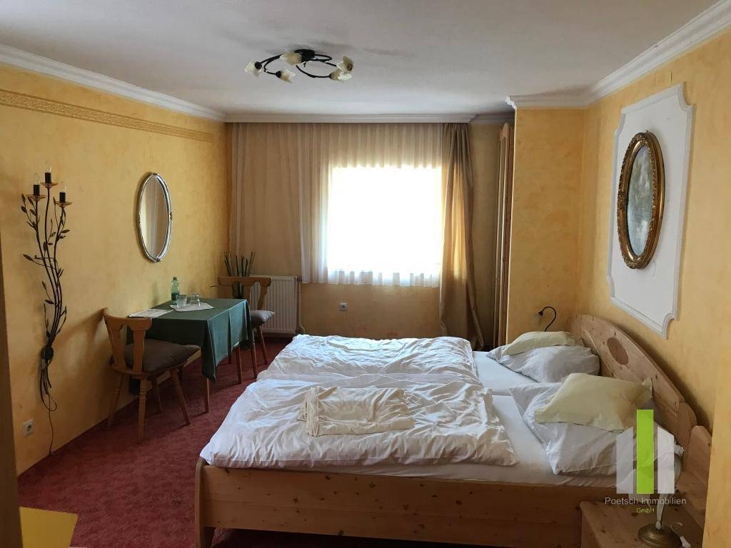 Gemütliches Schlafzimmer mit zwei Einzelbetten, Teppichboden und gelben Wänden.