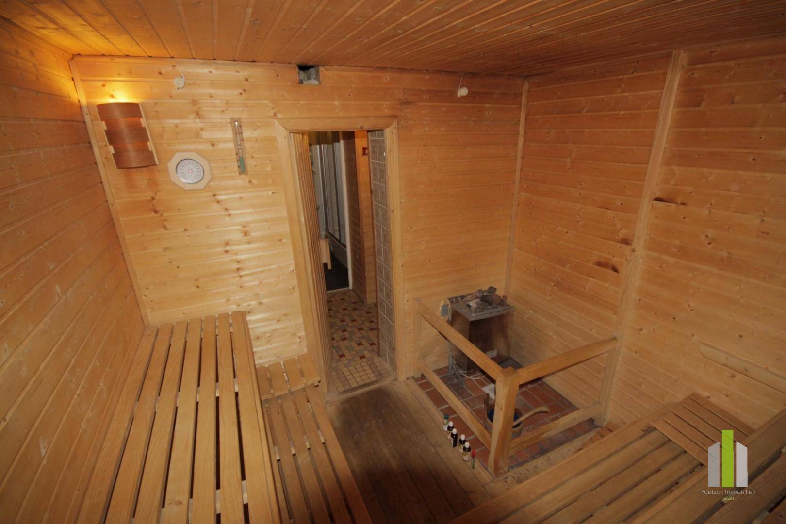 Traditionelle Holzsauna mit Bänken und Saunaofen, perfekt zur Entspannung nach einem aktiven Tag.