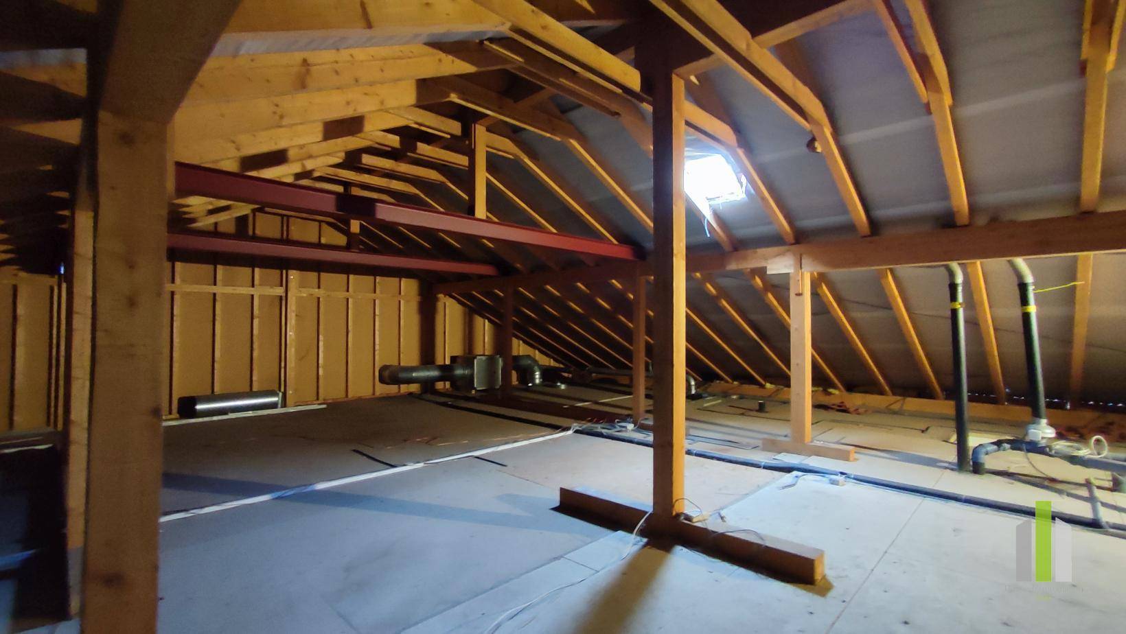 Dachboden mit sichtbaren Holzbalken und Dachschrägen, bereit für einen Ausbau oder als Lagerfläche.