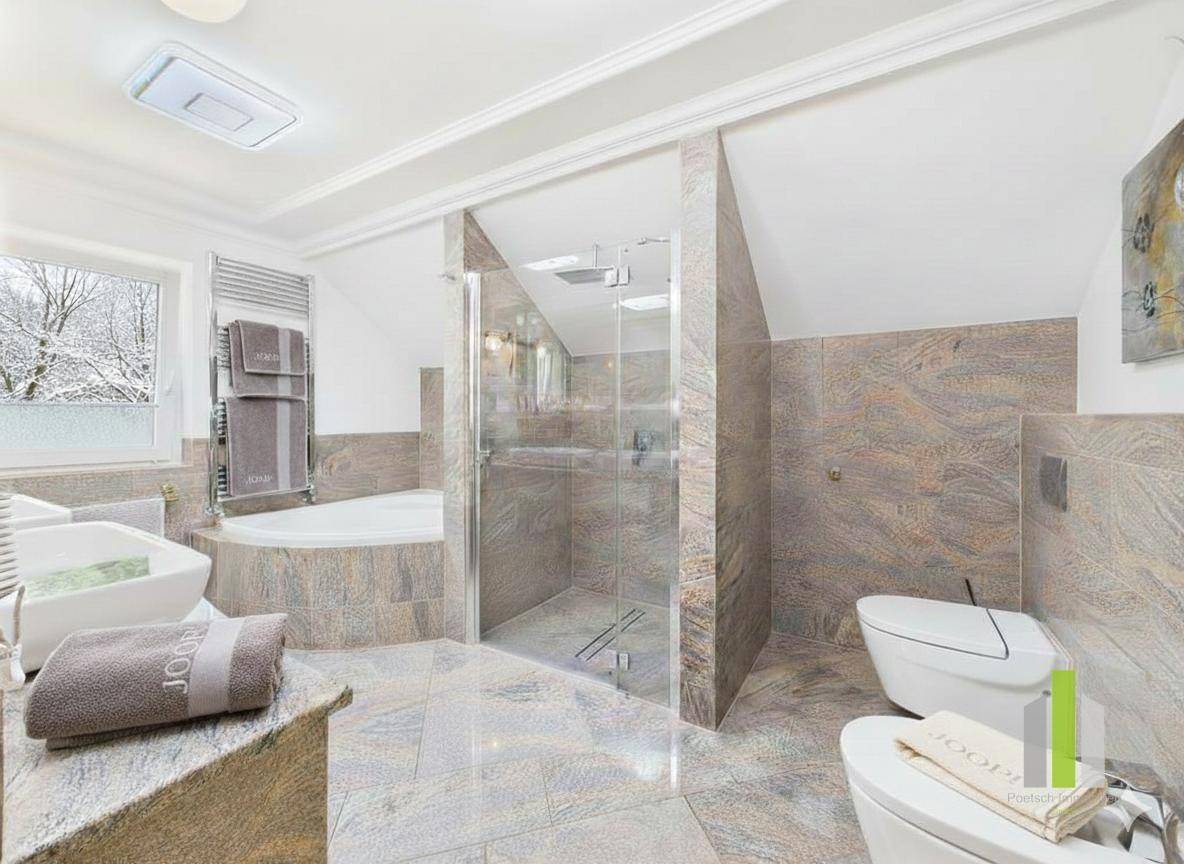 Modernes Badezimmer mit Eckbadewanne, begehbarer Dusche, zwei Toiletten und beheiztem Handtuchhalter.