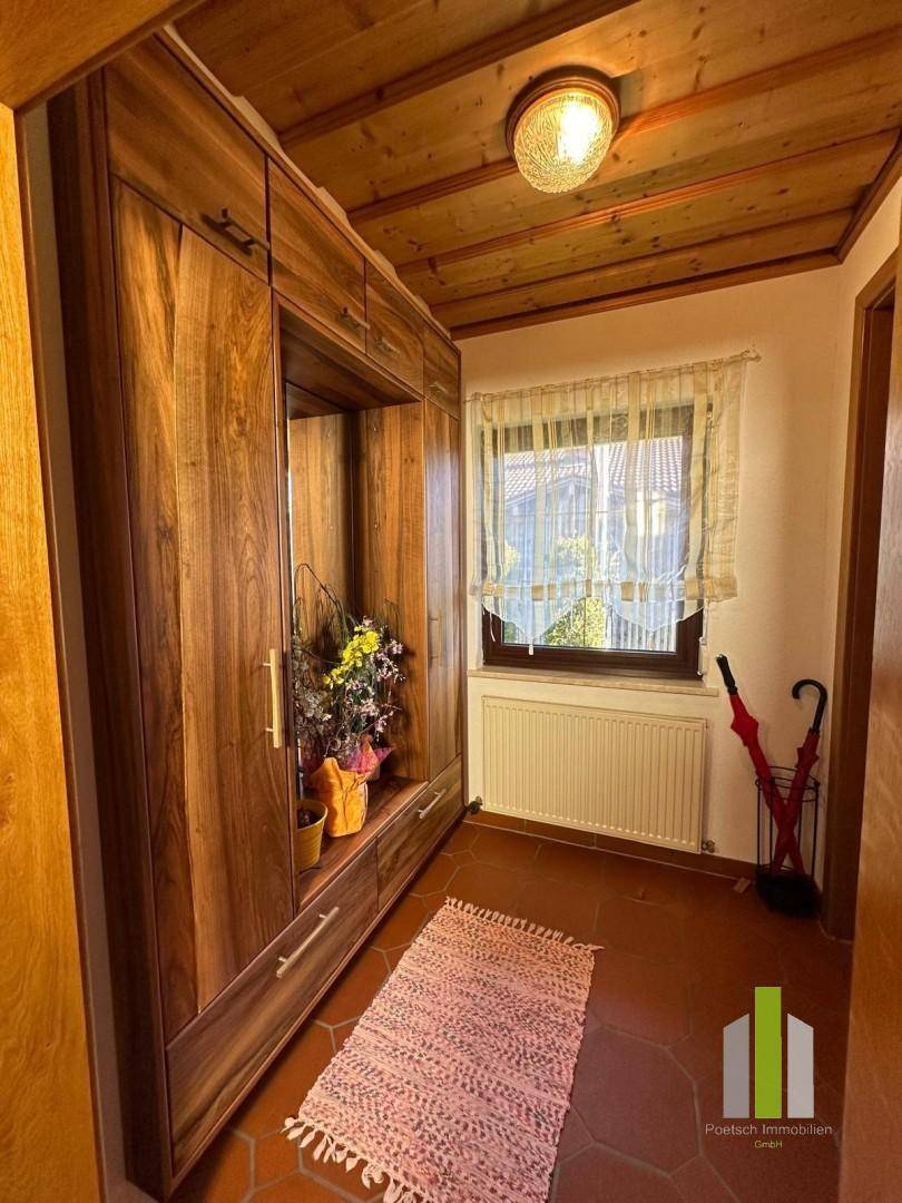 Heller Flur mit Einbauschrank, Holzdecke und Terrakottafliesen.