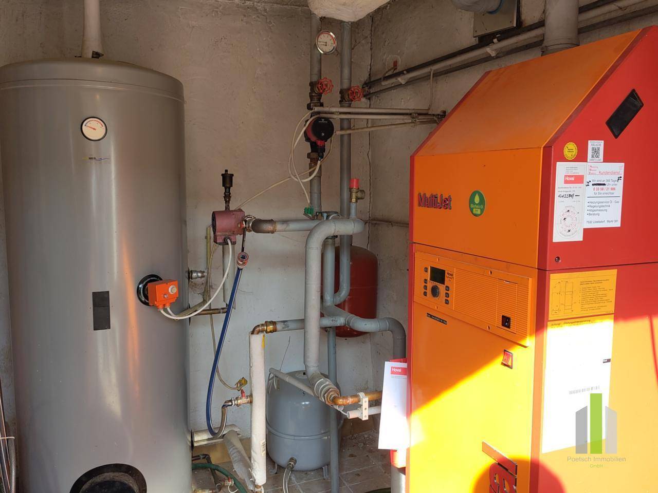 Heizungsraum mit moderner Heizungsanlage und Warmwasserspeicher.