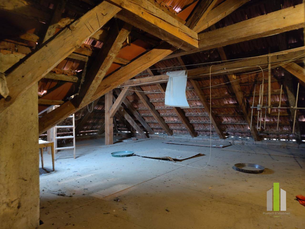 Geräumiger Dachboden mit sichtbaren Holzbalken und viel Stauraum.