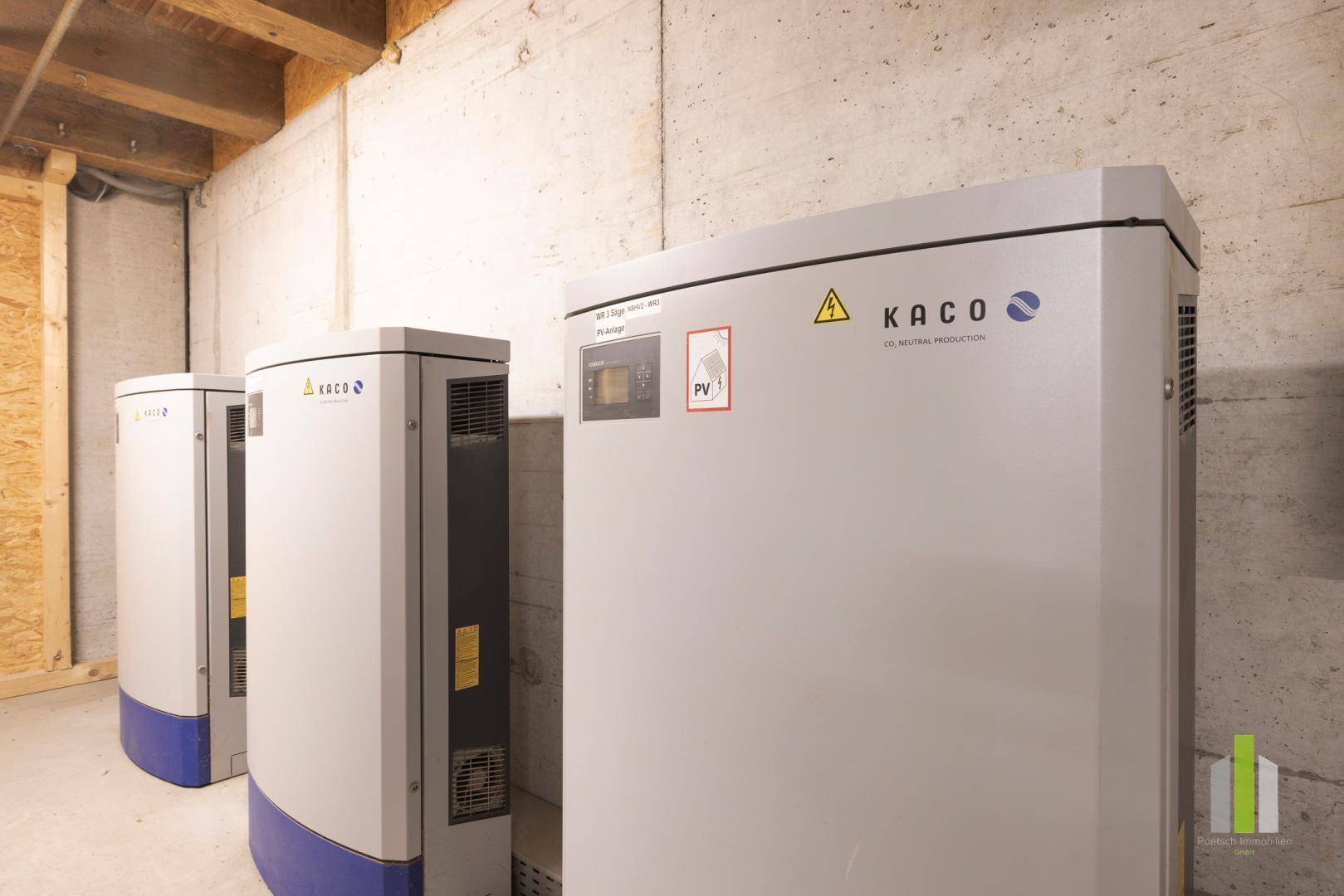 Technikraum mit mehreren großen Kaco-Wechselrichtern und einer Betonwand im Hintergrund.