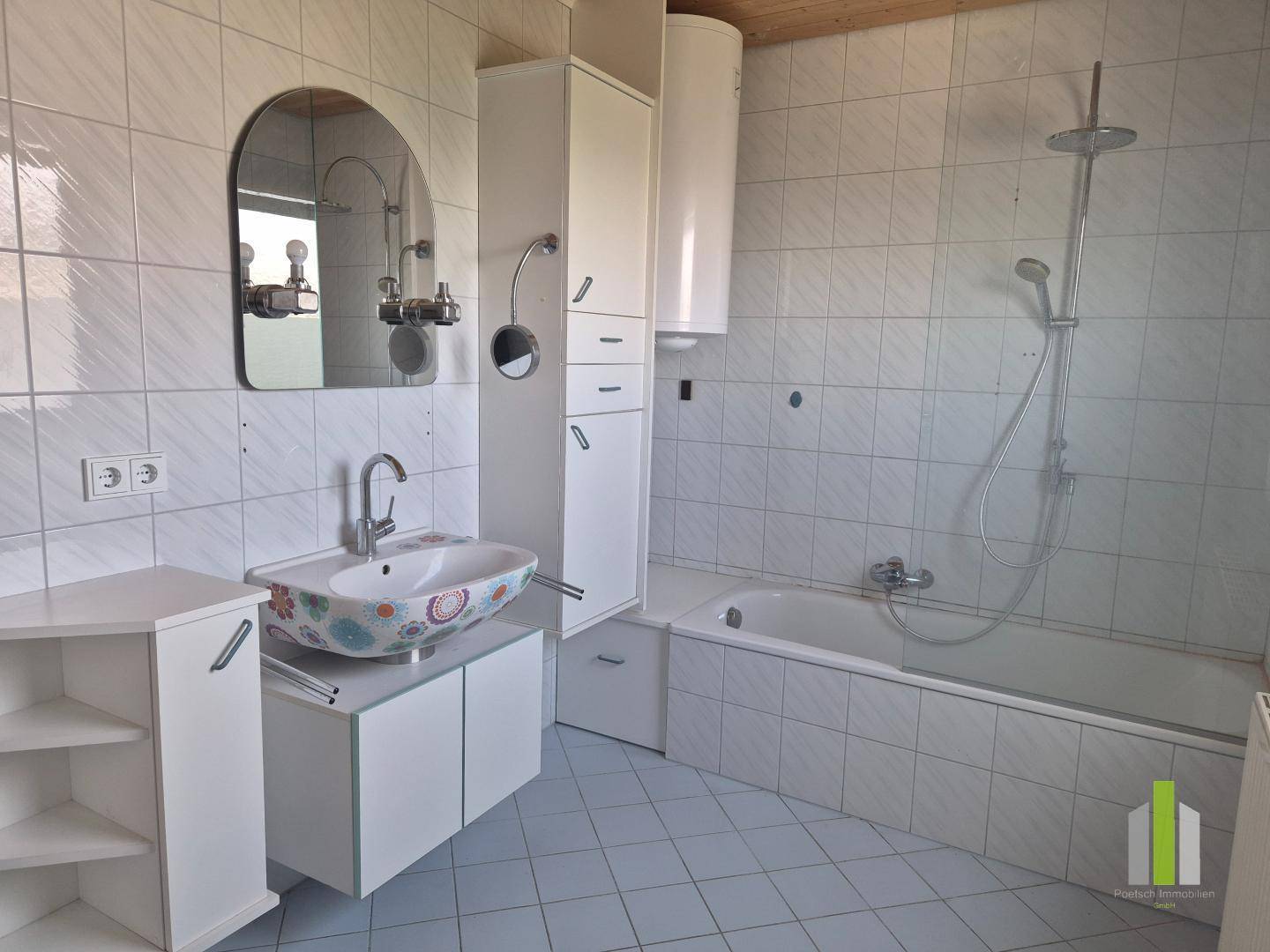 Gefliestes Badezimmer mit Badewanne, Waschbecken und Spiegelschrank, in hellem Design.