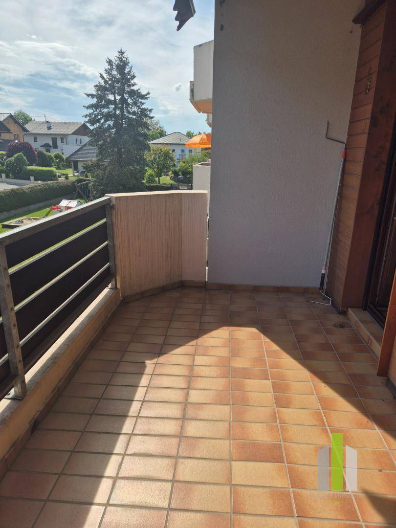 Gefliester Balkon mit Metallgeländer und Blick auf die umliegende Wohngegend.