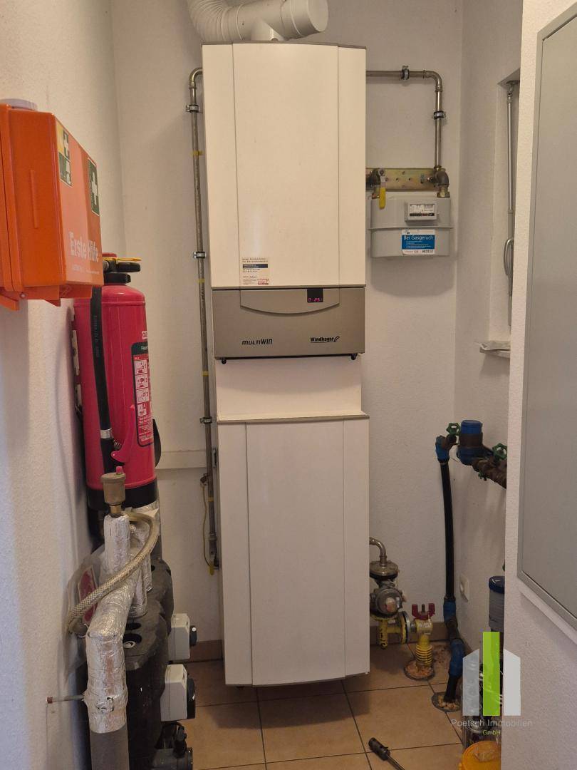 Hauswirtschaftsraum mit Heizungsanlage, Warmwasserspeicher und Fliesenboden.
