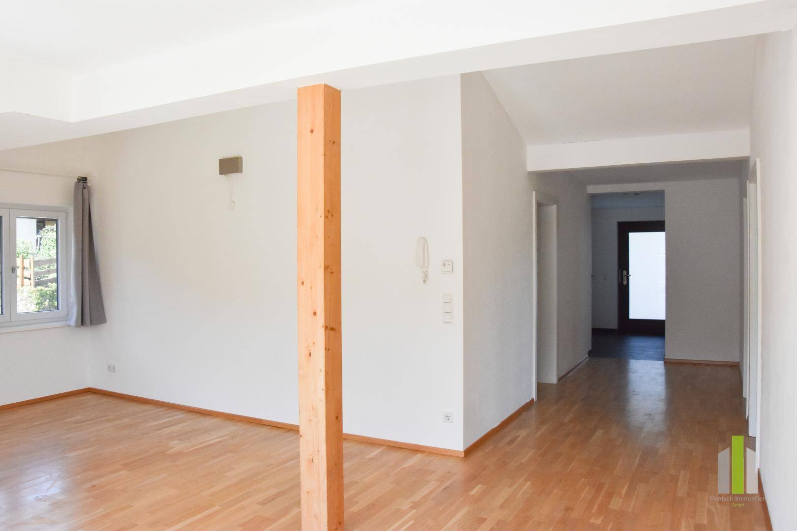 Heller Flur mit Holzboden, der zu den verschiedenen Räumen der Wohnung führt.