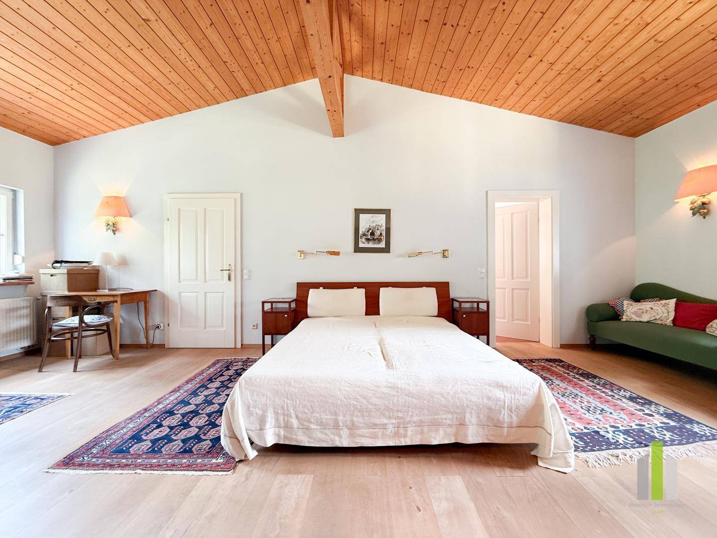 Geräumiges Schlafzimmer mit Holzbalkendecke, Holzboden und traditionellen Möbeln.