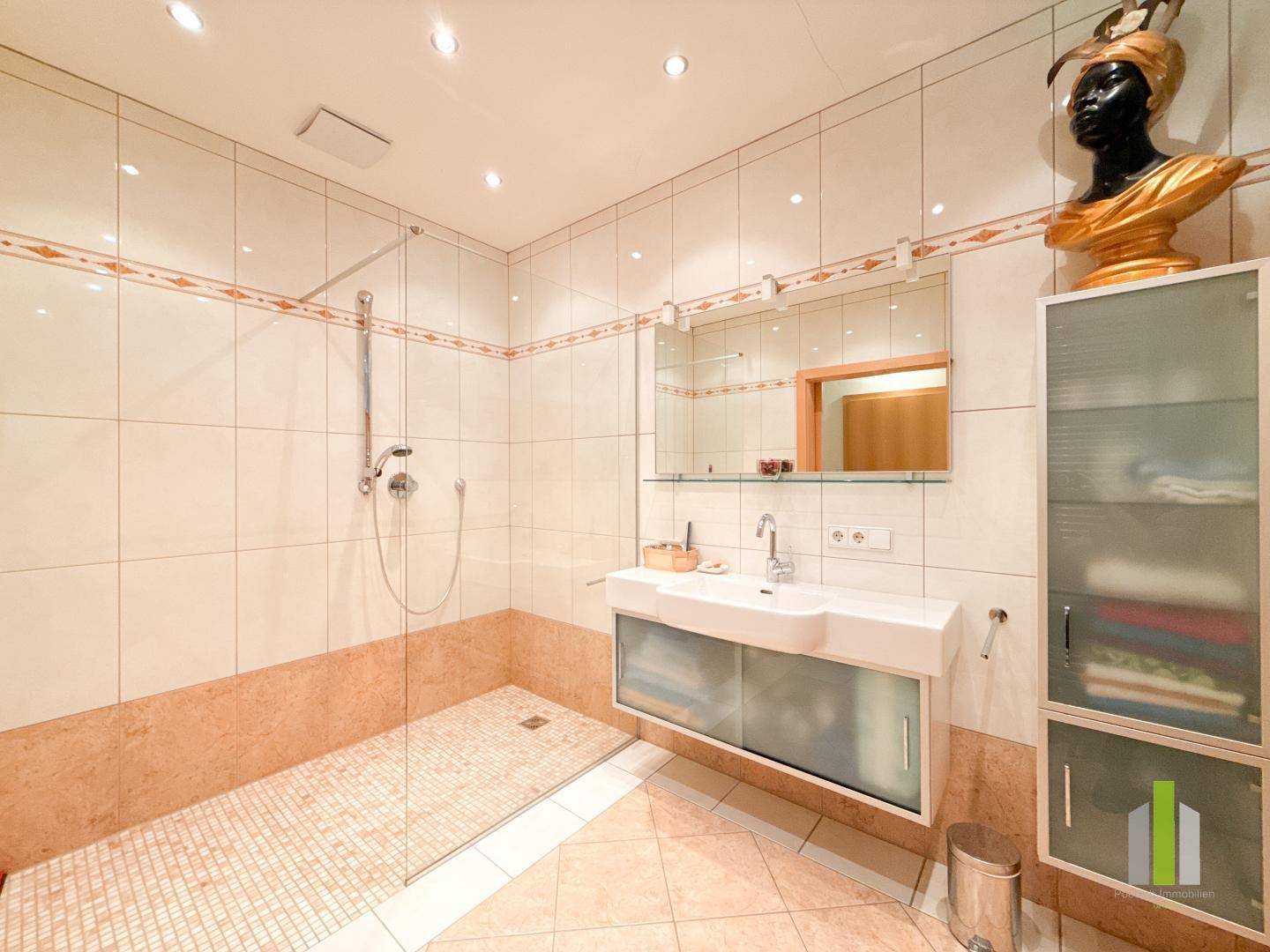 Modernes Badezimmer mit begehbarer Dusche, Doppelwaschbecken und Einbauschränken.