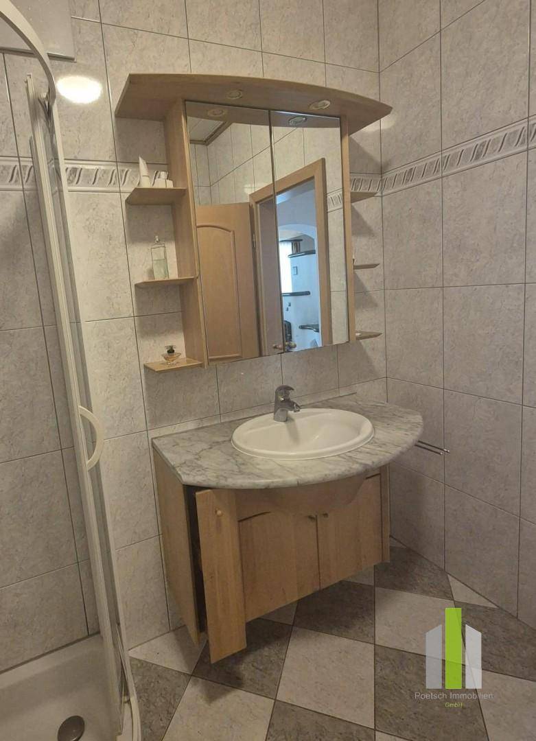 Waschbecken mit Unterschrank und Spiegelschrank im Badezimmer.
