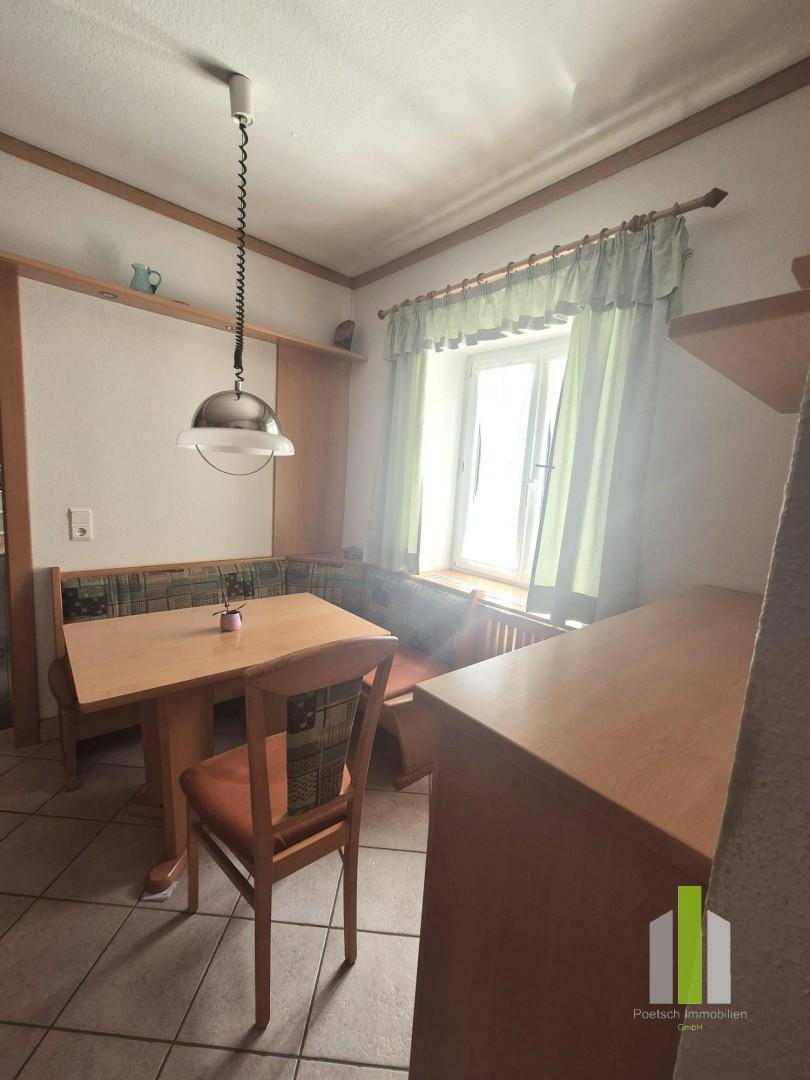 Gemütliche Essecke in der Küche mit Holztisch, Eckbank und Fenster.