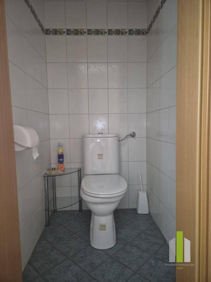 Separate Toilette mit Fliesen an Wänden und Boden, einfach und funktional.