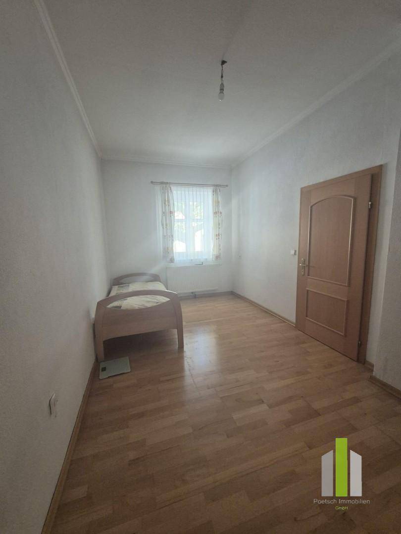 Gemütliches Schlafzimmer mit Holzboden und Einzelbett, ideal als Gästezimmer.