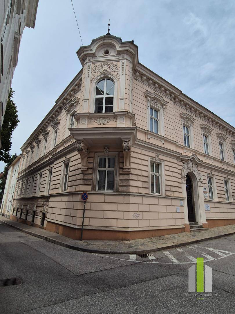 Historisches Eckgebäude mit detailreicher Fassade und traditioneller Architektur an einer Straße.