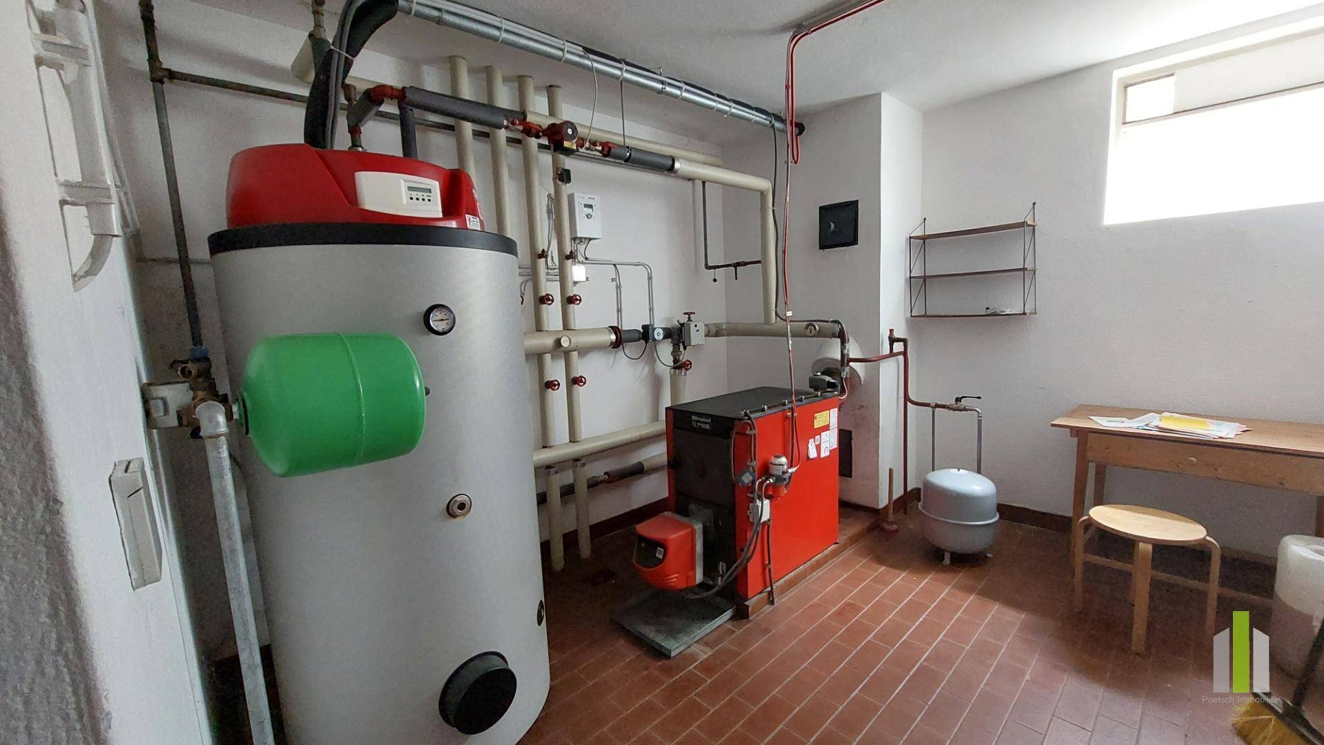 Heizungsraum mit Warmwasserspeicher und Heizkessel, funktional und gut organisiert.