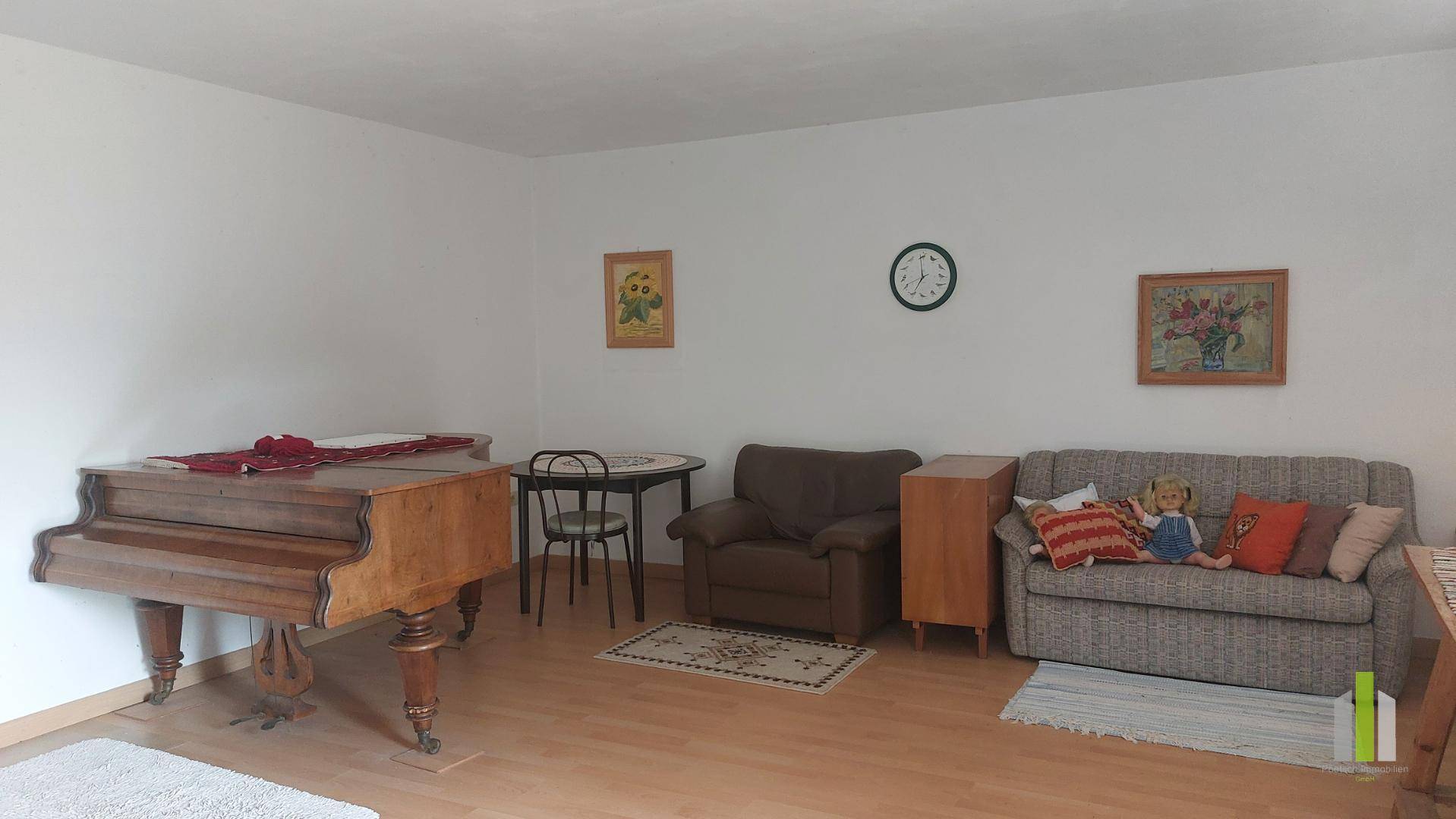 Geräumiges Wohnzimmer mit Klavier, Sofa und Esstisch, hell und freundlich gestaltet.
