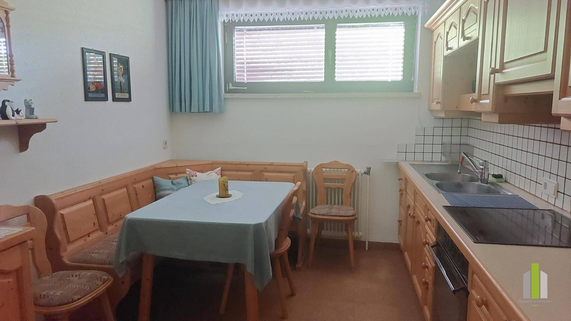 Traditionelle Holzküche mit Eckbank, Esstisch und Fenster, ideal für Familienmahlzeiten.