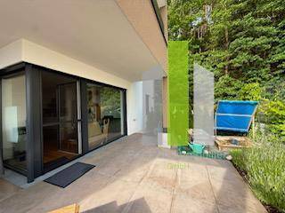 Geräumige Terrasse im Erdgeschoss mit großen Glasschiebetüren und Zugang zum Garten.