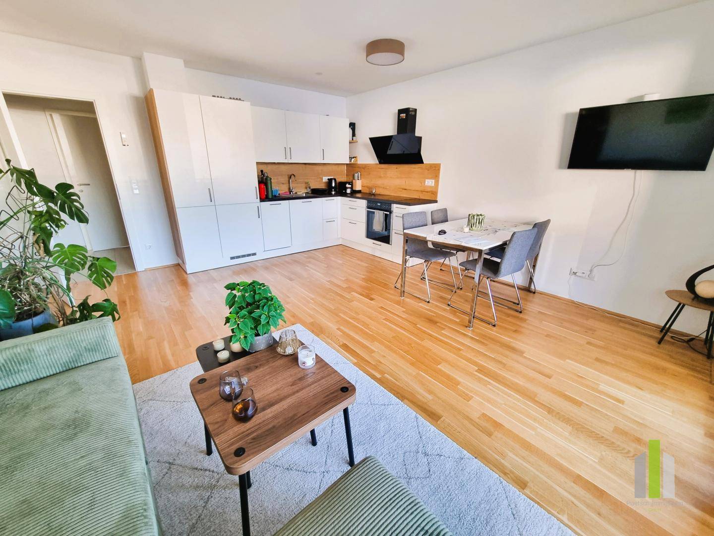 Gemütlicher Wohnbereich mit integrierter Küche, Esstisch und moderner Dekoration, ideal für geselliges Beisammensein.